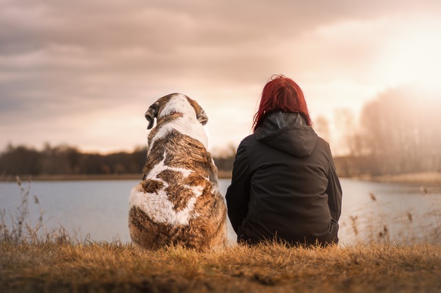 Dog and woman sitting by river